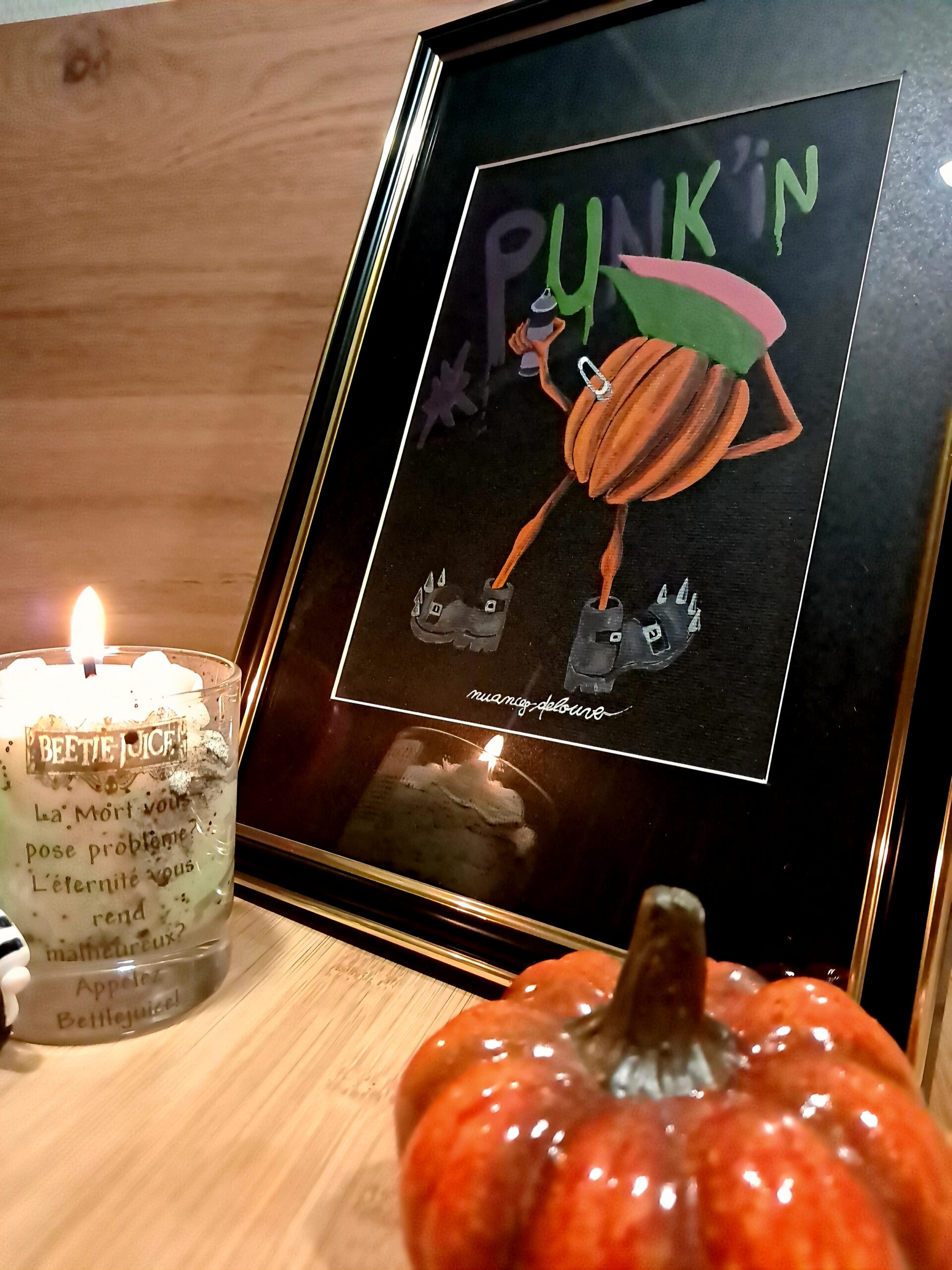 Punk'in, aquarelle originale sur papier noir encadré, photographiée avec une citrouille et une bougie dans une ambiance automnale.