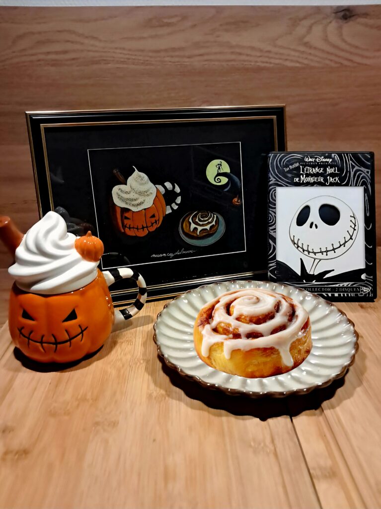 Aquarelle originale The Nightmare Before Michaelmas représentant une tasse citrouille, un cinnamon roll et un écran inspiré de The Nightmare Before Christmas sur papier noir.