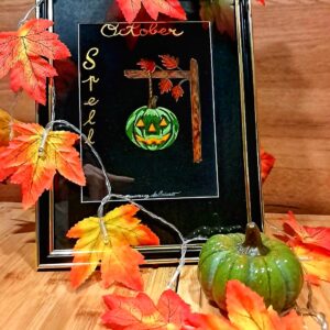 Aquarelle originale October Spell représentant une citrouille verte suspendue à une poutre en bois, entourée de feuilles d'automne oranges.